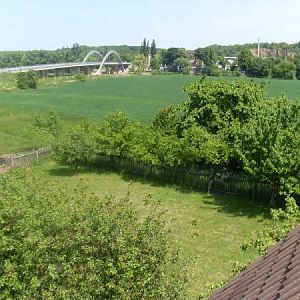 Blick aus dem Giebelfenster auf Grundstück und Landschaft.