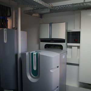 Technikraum mit DV/DK-WP (Mitte), Warmwasserspeicher (links), (offenen) WR und Zählerschrank